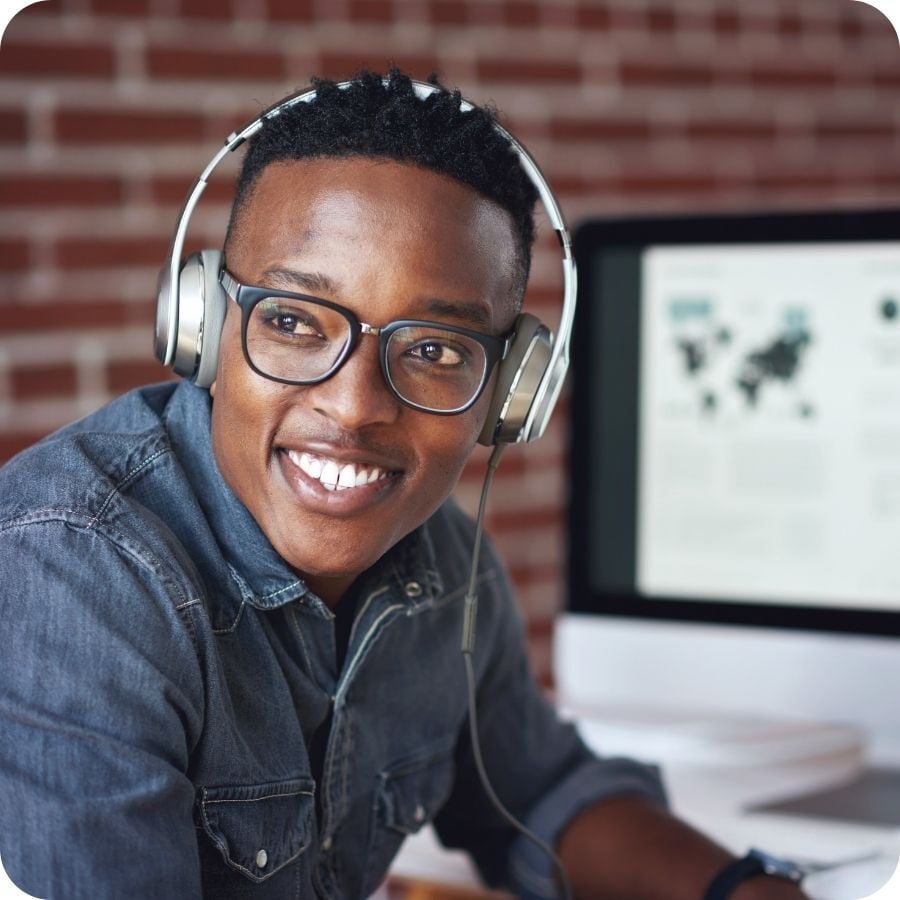 young black man smiling computer behind him